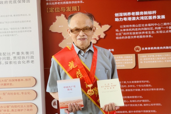 修改图异地党员张训诗接到纪念章、绶带和学习书籍开心留影.jpg