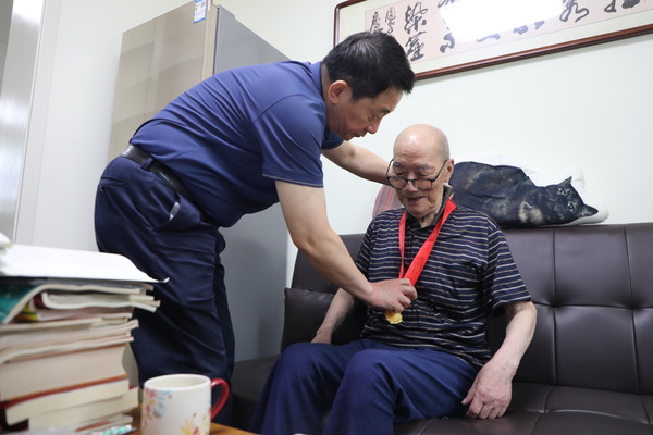 修改图院党委书记、院长杨立新同志为94岁的老党员陈学章佩戴在党50年纪念章.jpg
